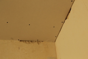 niewłaściwe wykończenia na styku ściany tynkowanej i sufitu podwieszanego z płyt g-k